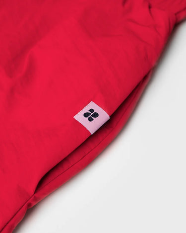Vivid red vegan skirt made from recycled materials with small black logo tag. - The New Orchard CH