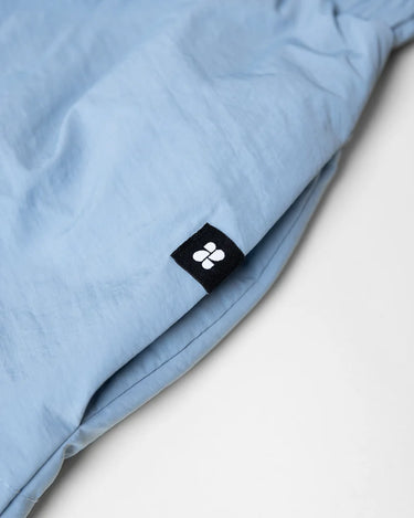 Sky blue vegan skirt made from recycled materials with black logo tag detail. - The New Orchard CH