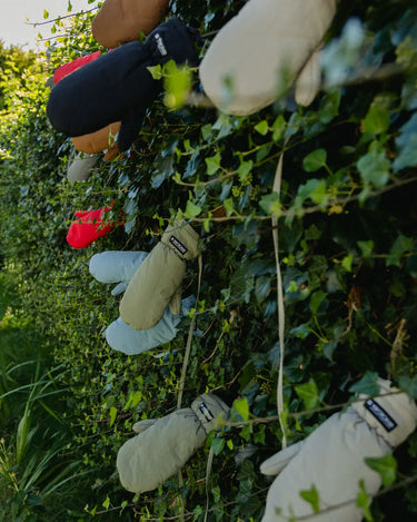 Vegan winter gloves in cinnamon brown and cream, made from recycled materials, hanging outdoors. - The New Orchard CH