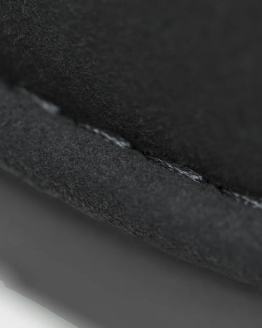 Close-up of boot black fabric with a visible seam on a white background