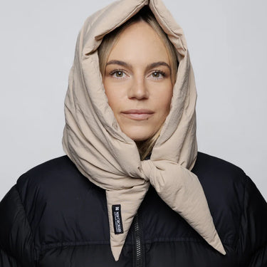 Light beige vegan winter capuche made from recycled materials, styled over black jacket. - The New Orchard CH