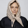 Light beige vegan winter capuche made from recycled materials, styled over black jacket. - The New Orchard CH