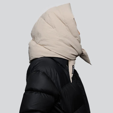 Light beige vegan puffer hood made from recycled materials, styled over black jacket. - The New Orchard CH