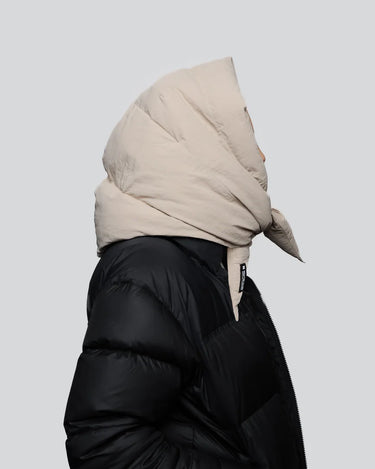 Light beige vegan puffer hood made from recycled materials, styled over black jacket. - The New Orchard CH