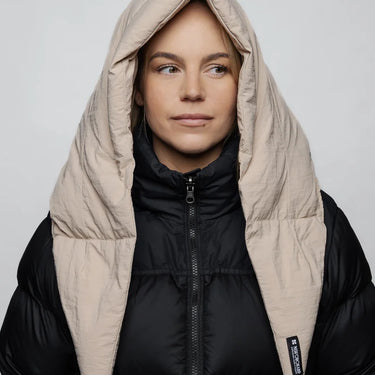 Light beige vegan winter capuche made from recycled materials worn over a black puffer jacket. - The New Orchard CH