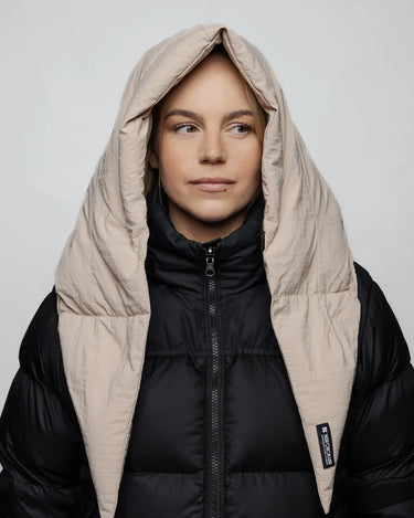 Light beige vegan winter capuche made from recycled materials worn over a black puffer jacket. - The New Orchard CH