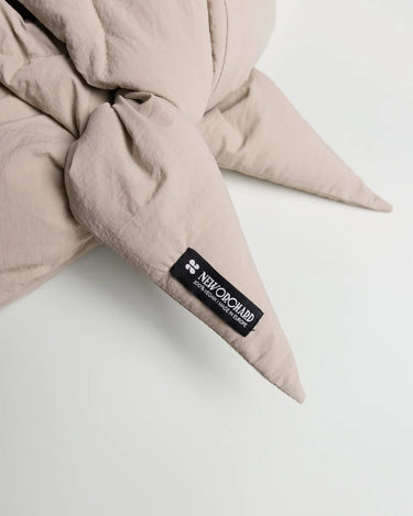 Light beige vegan capuche made from recycled materials with a soft, textured fabric and pointed ends. - The New Orchard CH