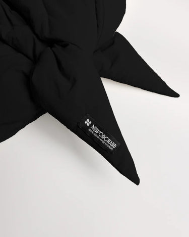 Black vegan winter capuche made from recycled materials with pointed ends and visible branded tag. - The New Orchard CH