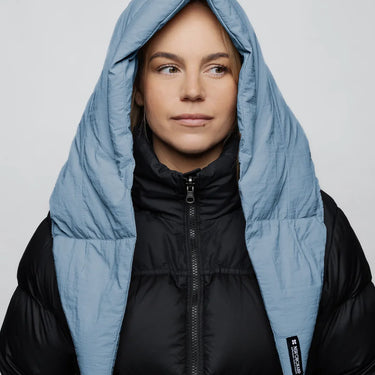 Sky blue vegan puffer winter capuche made from recycled materials, worn over black jacket. - The New Orchard CH