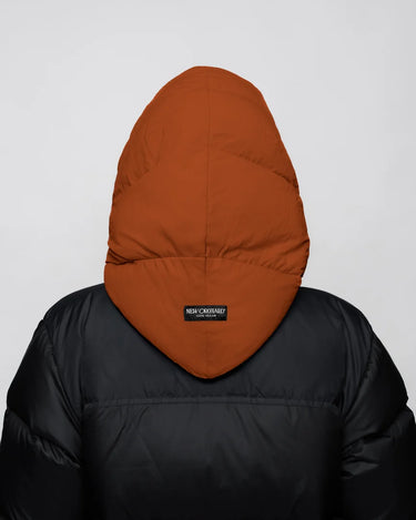 Black puffer jacket with vegan, recycled cinnamon-colored hood covering head, back view. - The New Orchard CH