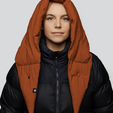 Vegan winter capuche in cinnamon color made from recycled materials, worn over black puffer jacket. - The New Orchard CH