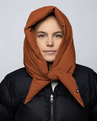 Vegan cinnamon-colored capuche made from recycled materials worn over black puffer jacket. - The New Orchard CH