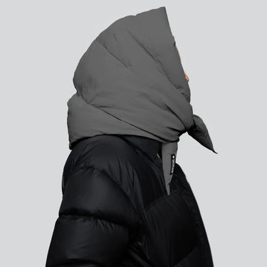 Black vegan puffer jacket with recycled materials and oversized grey hood covering head. - The New Orchard CH