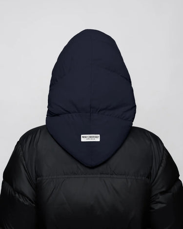 Navy blue vegan winter capuche made from recycled materials on black puffer jacket back view. - The New Orchard CH