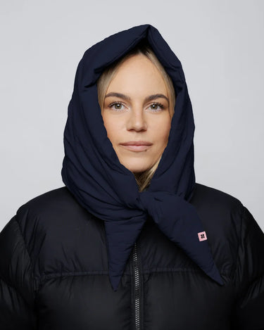 Navy vegan hood made from recycled materials with tied ends on model wearing black puffer jacket. - The New Orchard CH