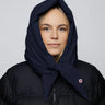 Navy vegan hood made from recycled materials with tied ends on model wearing black puffer jacket. - The New Orchard CH