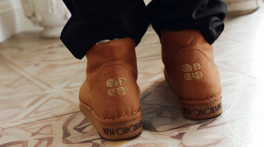 Brown suede shoes with brand logo on a patterned floor