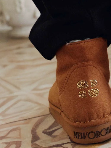 Brown suede shoe with brand logo on a patterned floor