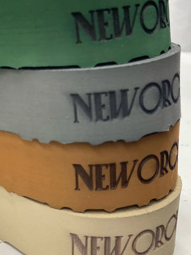 Stack of New Orchard shoe soles in different colors on a white surface.