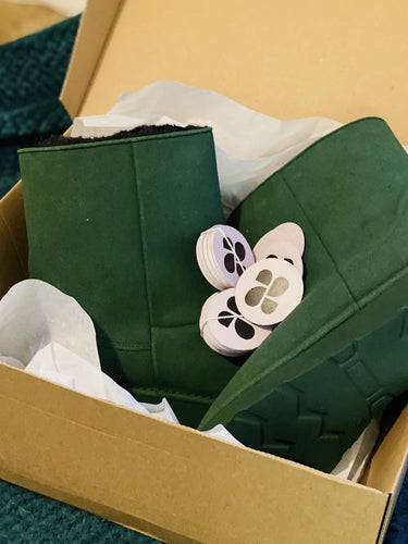 Green shoes with green soles in a cardboard box