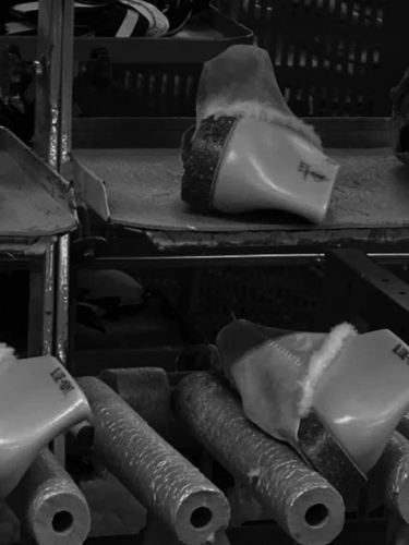 Row of plastic components on a conveyor belt in a factory setting