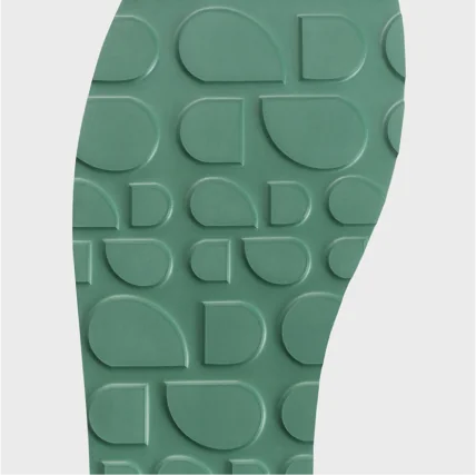 Close-up of a green shoe sole with a textured pattern on a white background